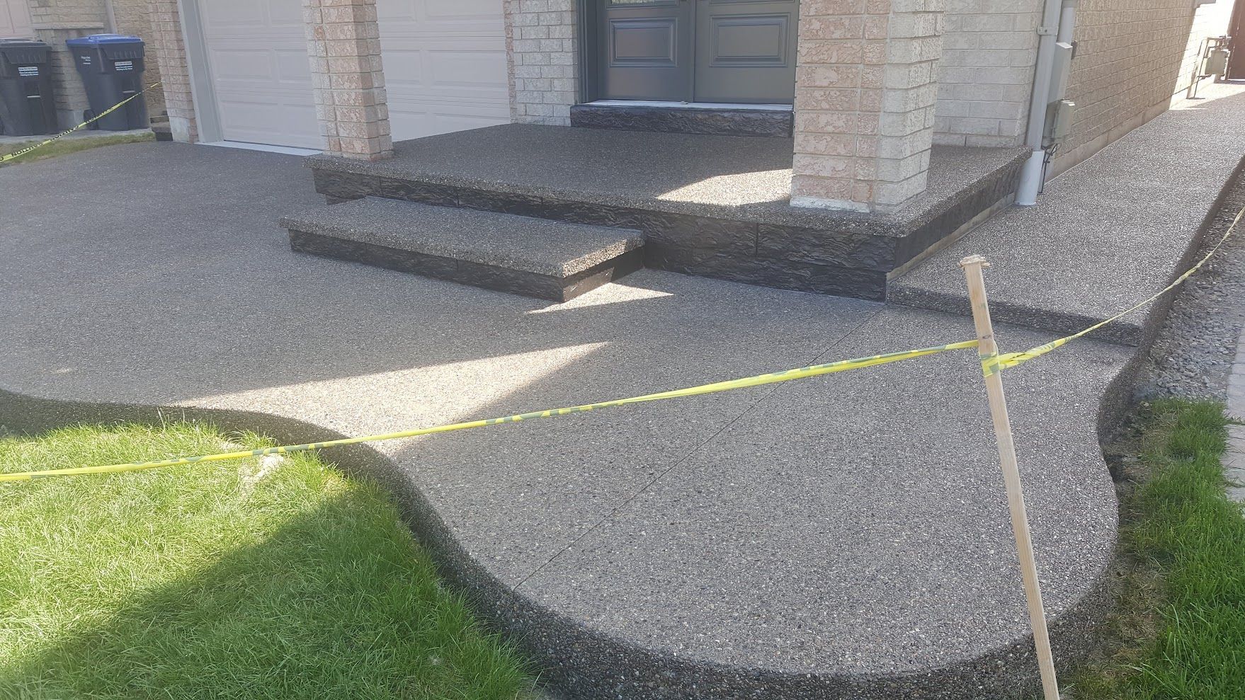 A concrete walkway with steps leading up to a house.