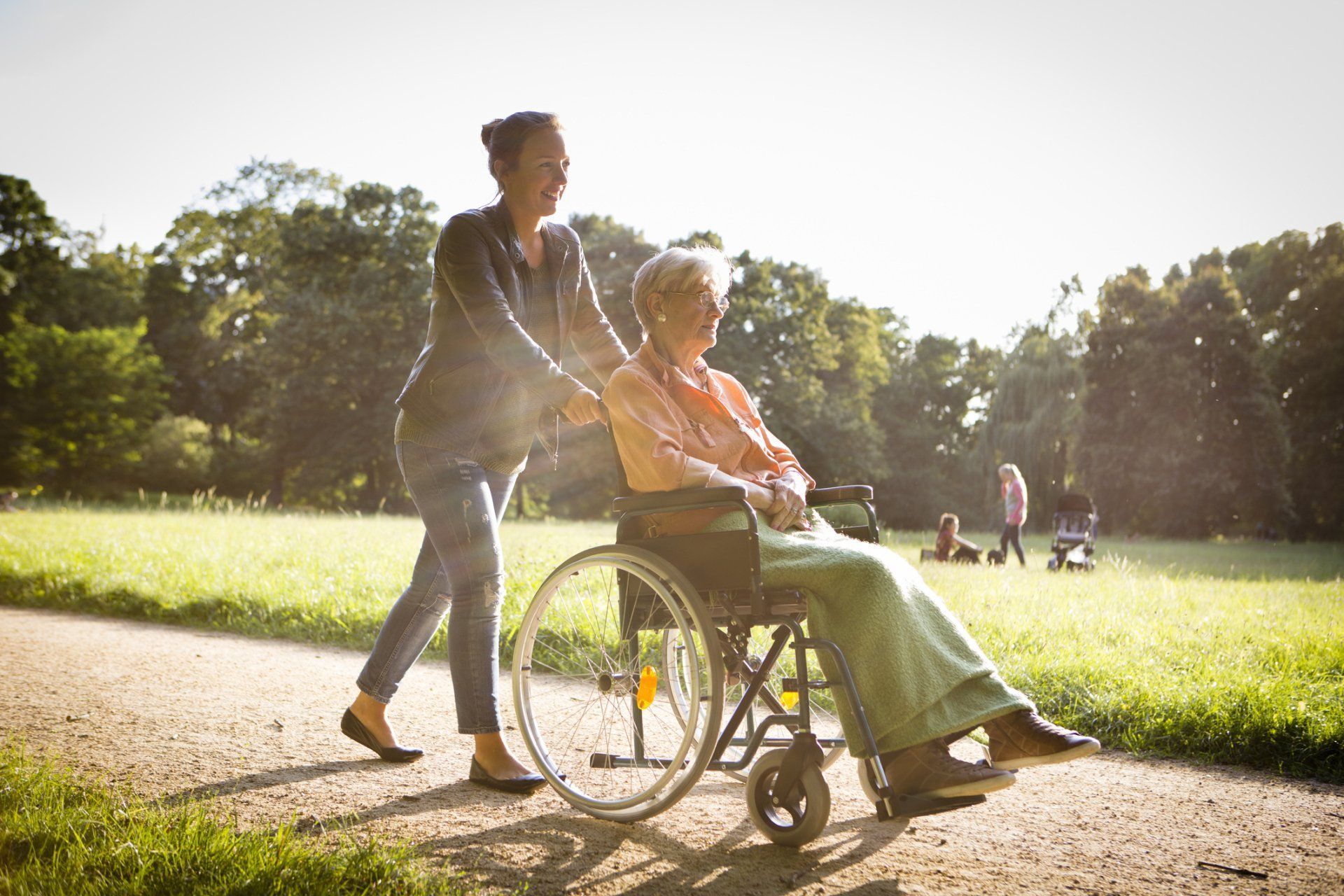A picture of woman pushing old woman in wheelchair