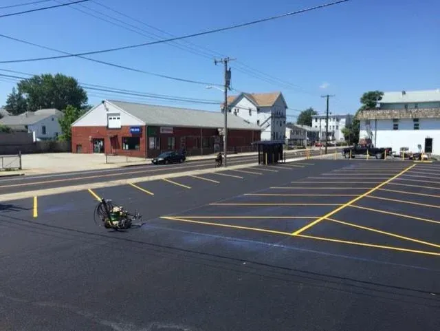 A parking lot is being painted with yellow lines.
