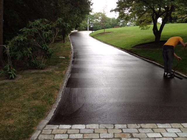A brown driveway with a garage in the background.