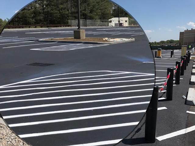 A parking lot is reflected in a round mirror