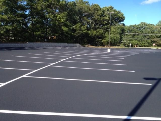An empty parking lot with trees in the background