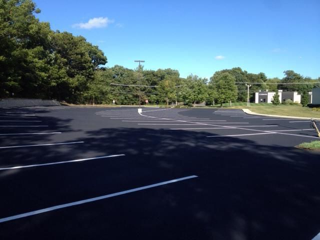 An empty parking lot with trees in the background