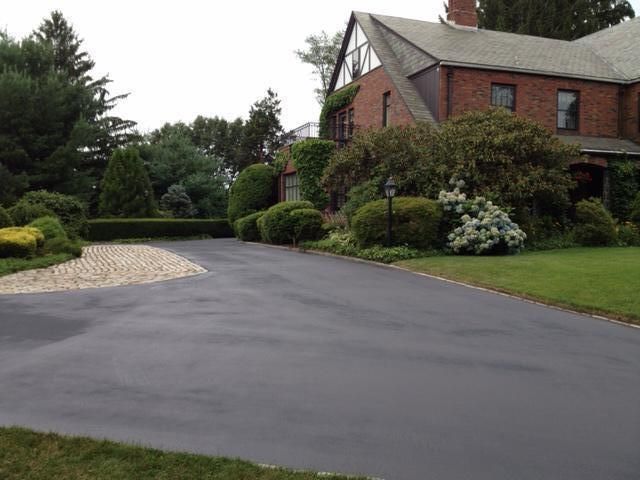 A large brick house with a driveway leading to it