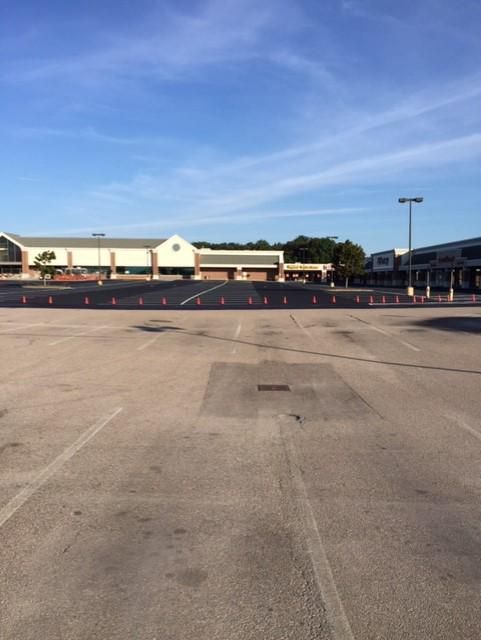 An empty parking lot with a building in the background