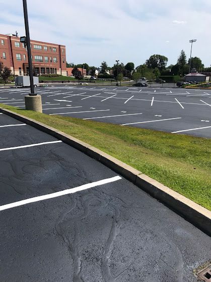 A parking lot with cars parked in it and a building in the background.