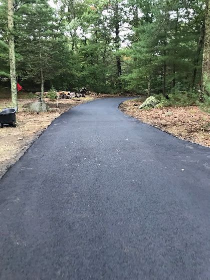 A black asphalt road in the middle of a forest.