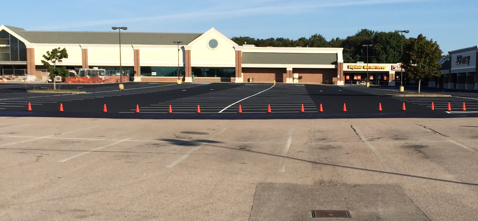 An empty parking lot with a large building in the background