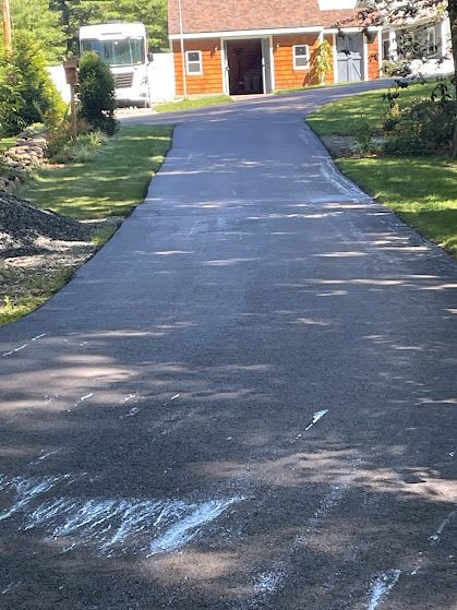 A driveway leading to a house with a rv parked on the side of it