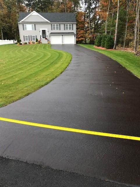 A driveway leading to a house with a yellow line on it