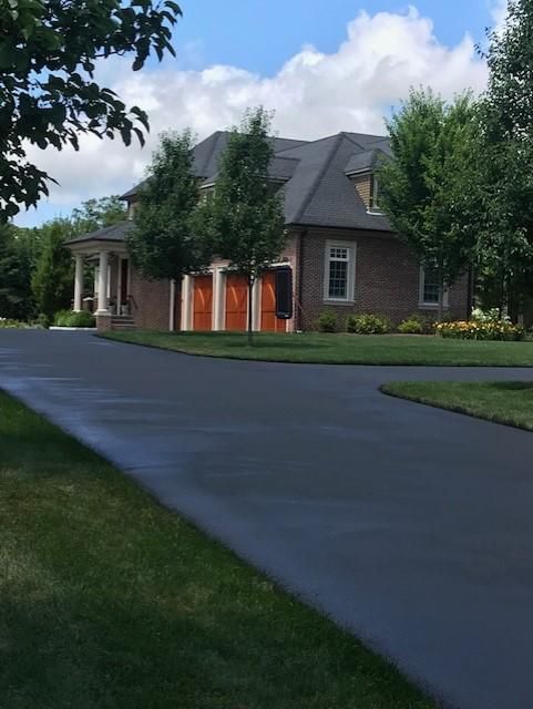 A large brick house with a driveway leading to it
