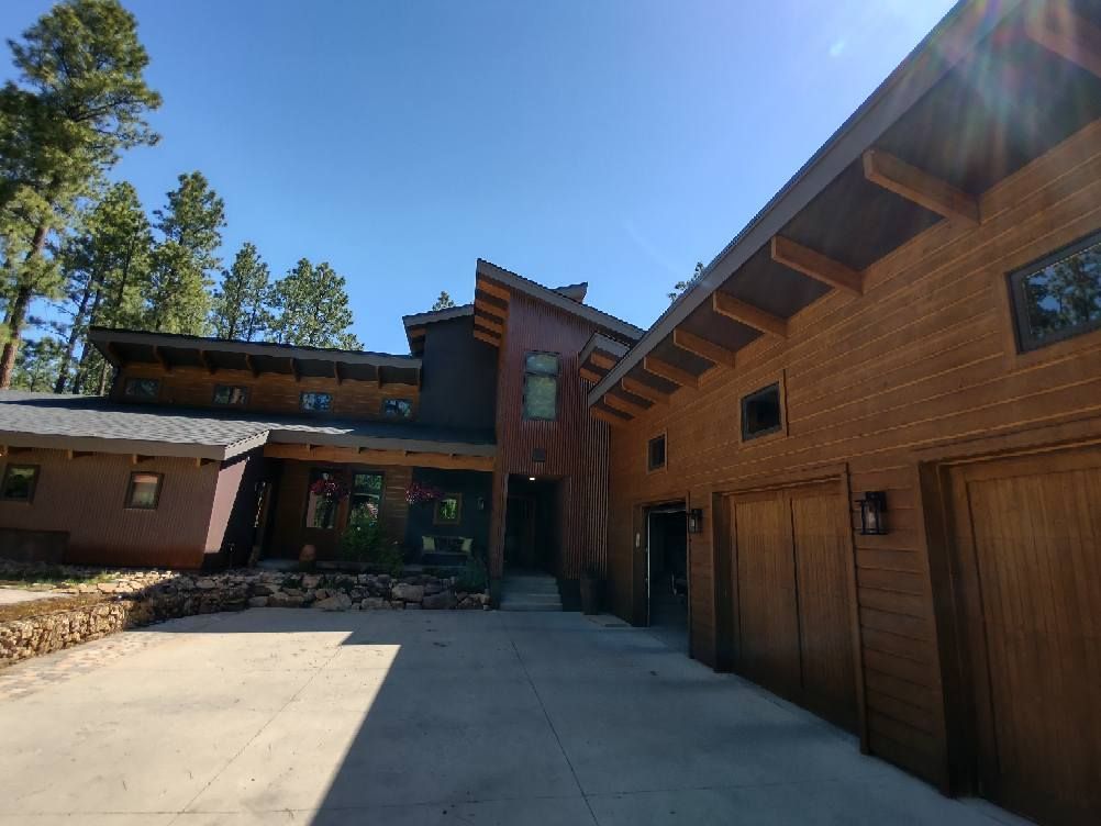 A house with a car parked in front of it and a bench in front of it. The house has received exterior painting services