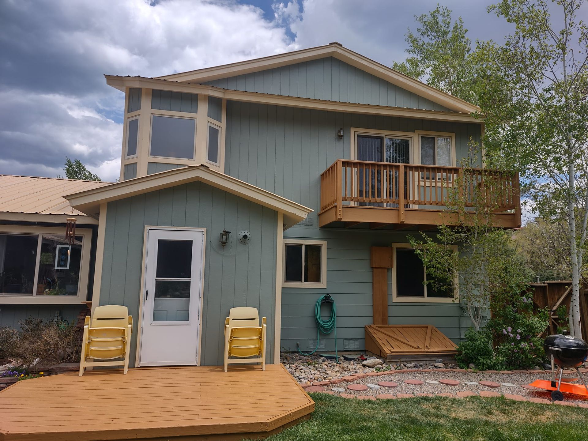 A house with a deck and chairs in front of it