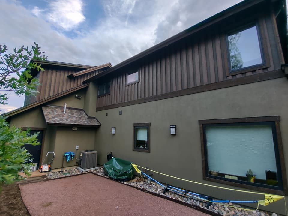 A large house with a lot of windows and a green tarp on the side of it.