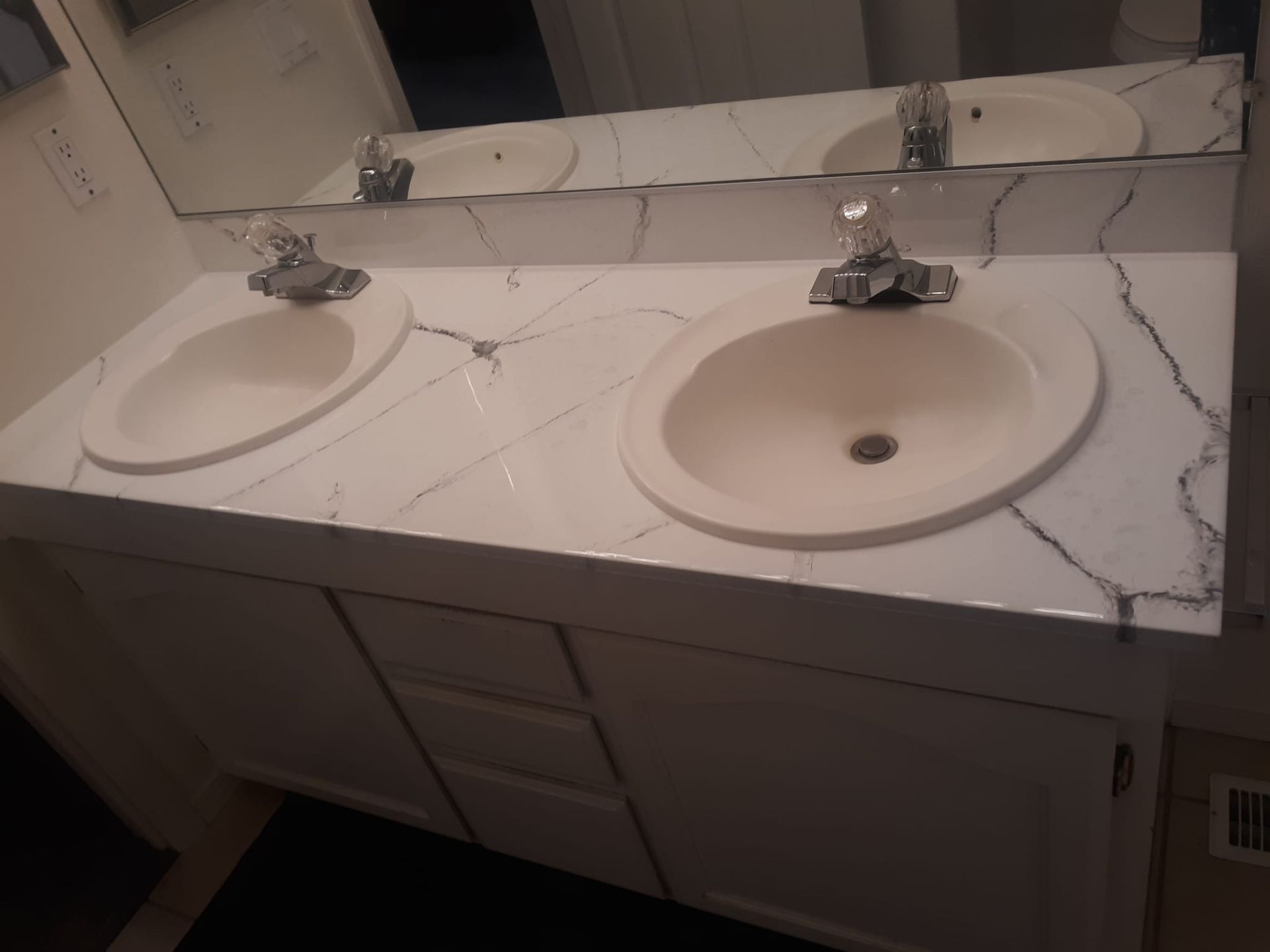 A bathroom with two sinks and a mirror. The sinks have epoxy added