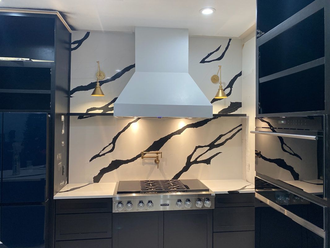 A kitchen with a stove top oven and a hood