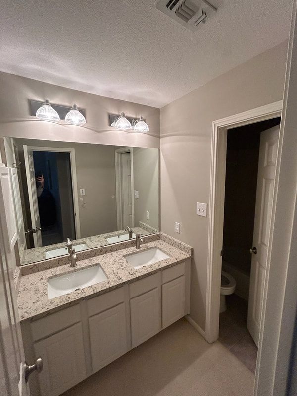 A bathroom with two sinks and a large mirror.