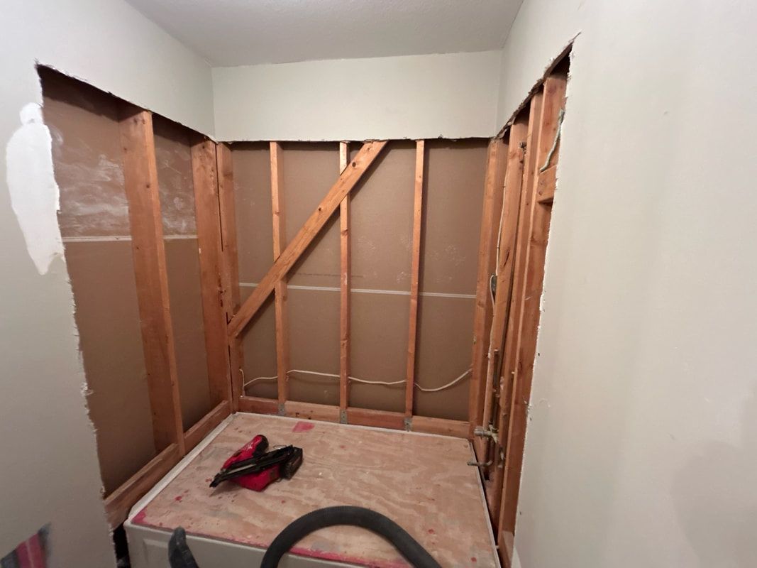 A room with wooden walls and a vacuum cleaner on the floor.