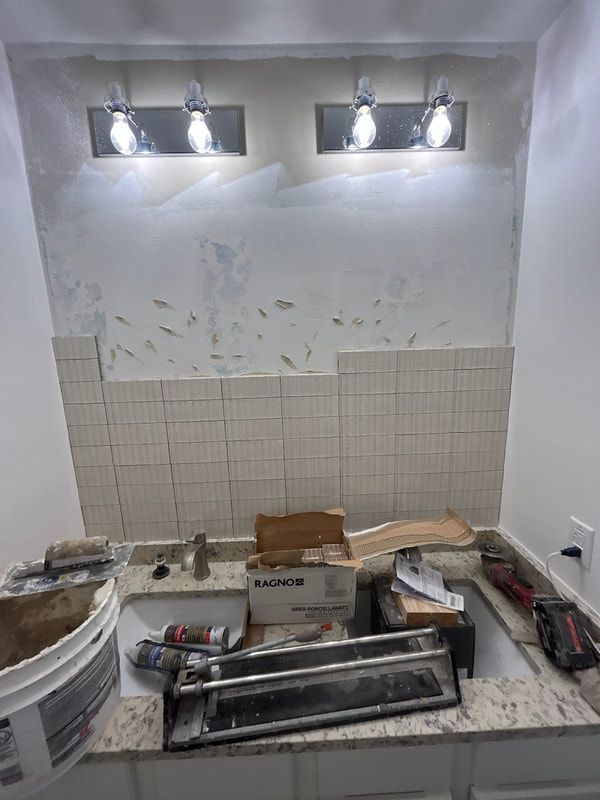 A bathroom under construction with a sink and a light fixture.