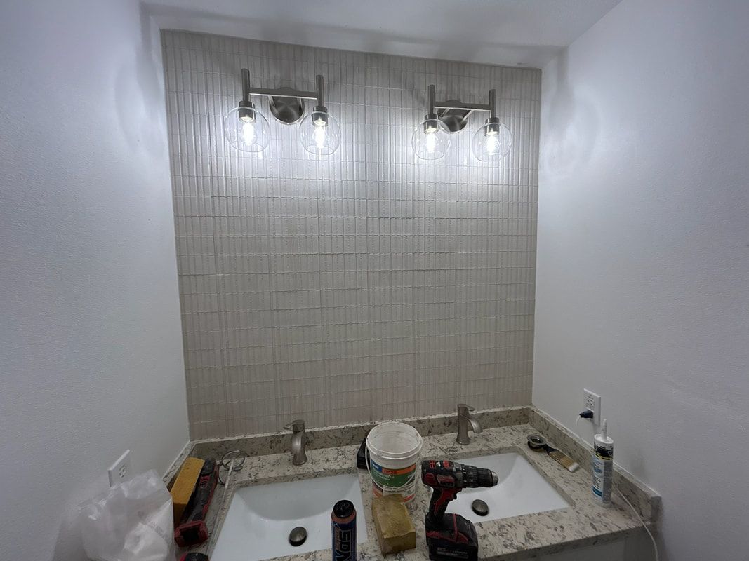A bathroom with a sink and two lights on the wall.