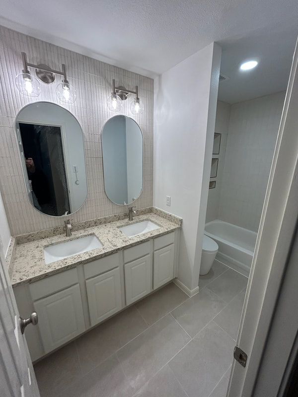 A bathroom with two sinks , two mirrors , a toilet and a bathtub.