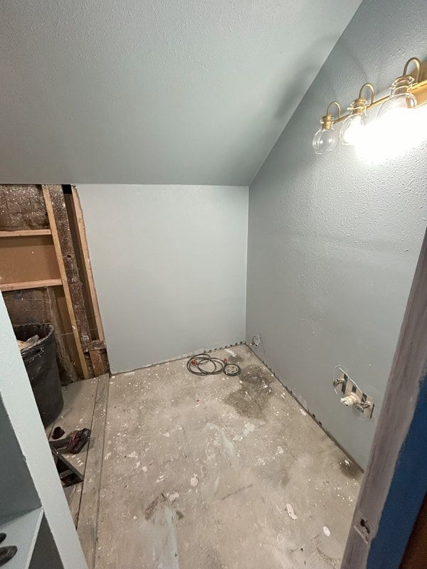 A bathroom under construction with a light on the wall.