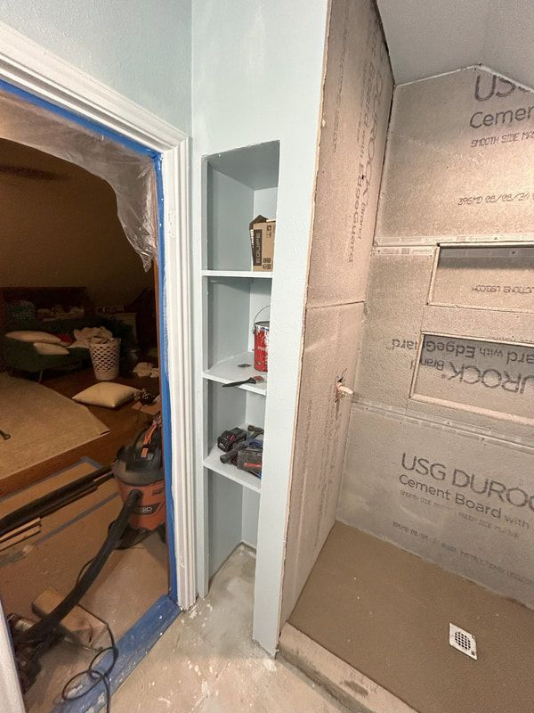 A room with a vacuum cleaner and shelves in it.