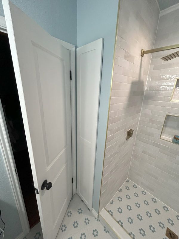 A bathroom with a walk in shower and a door.