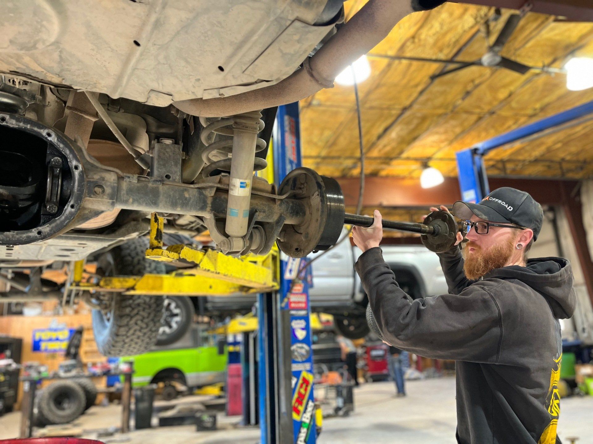 mechanic working under truck on wheel