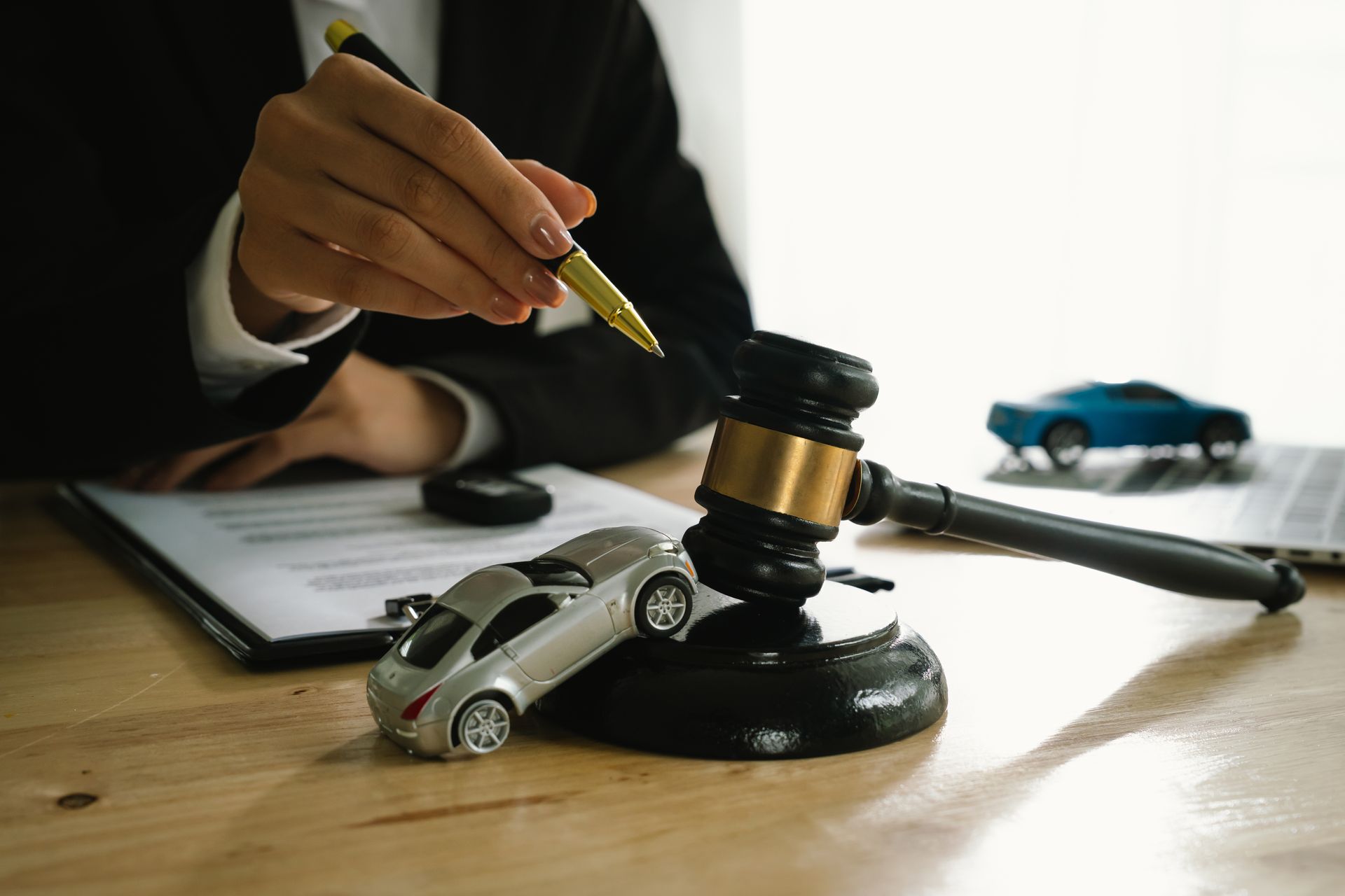 A toy car is on gravel as the lawyer reviews documents in the accident case.