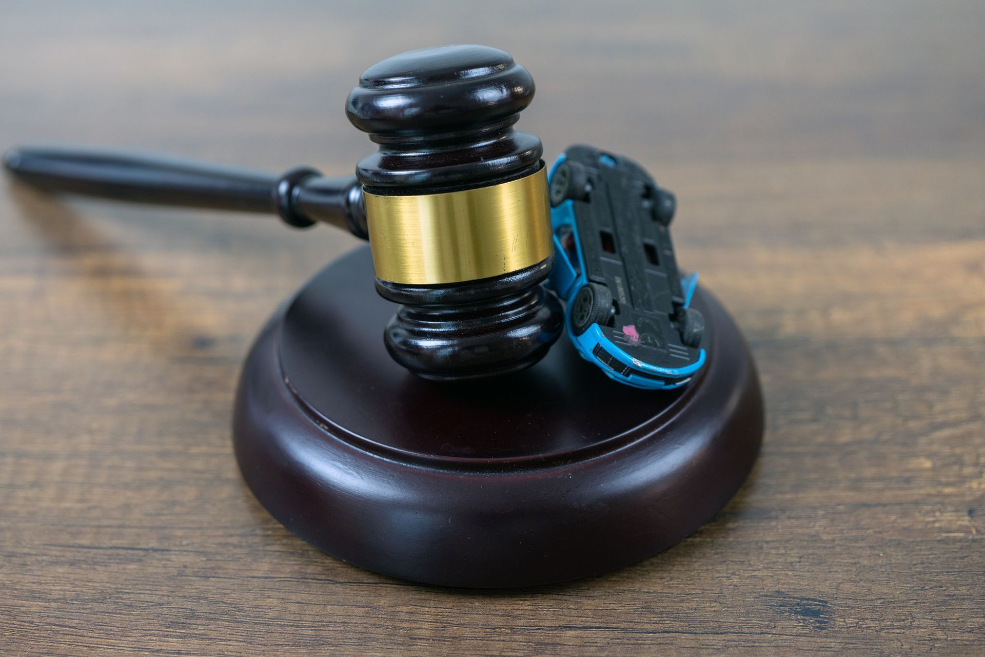 A gavel and a car model over a table.