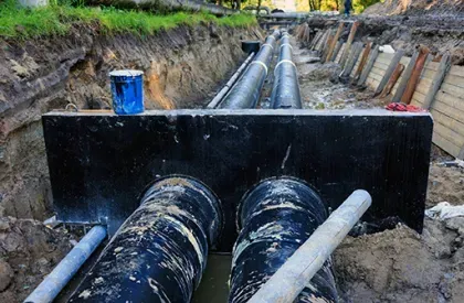 A bunch of pipes are being installed in a trench.
