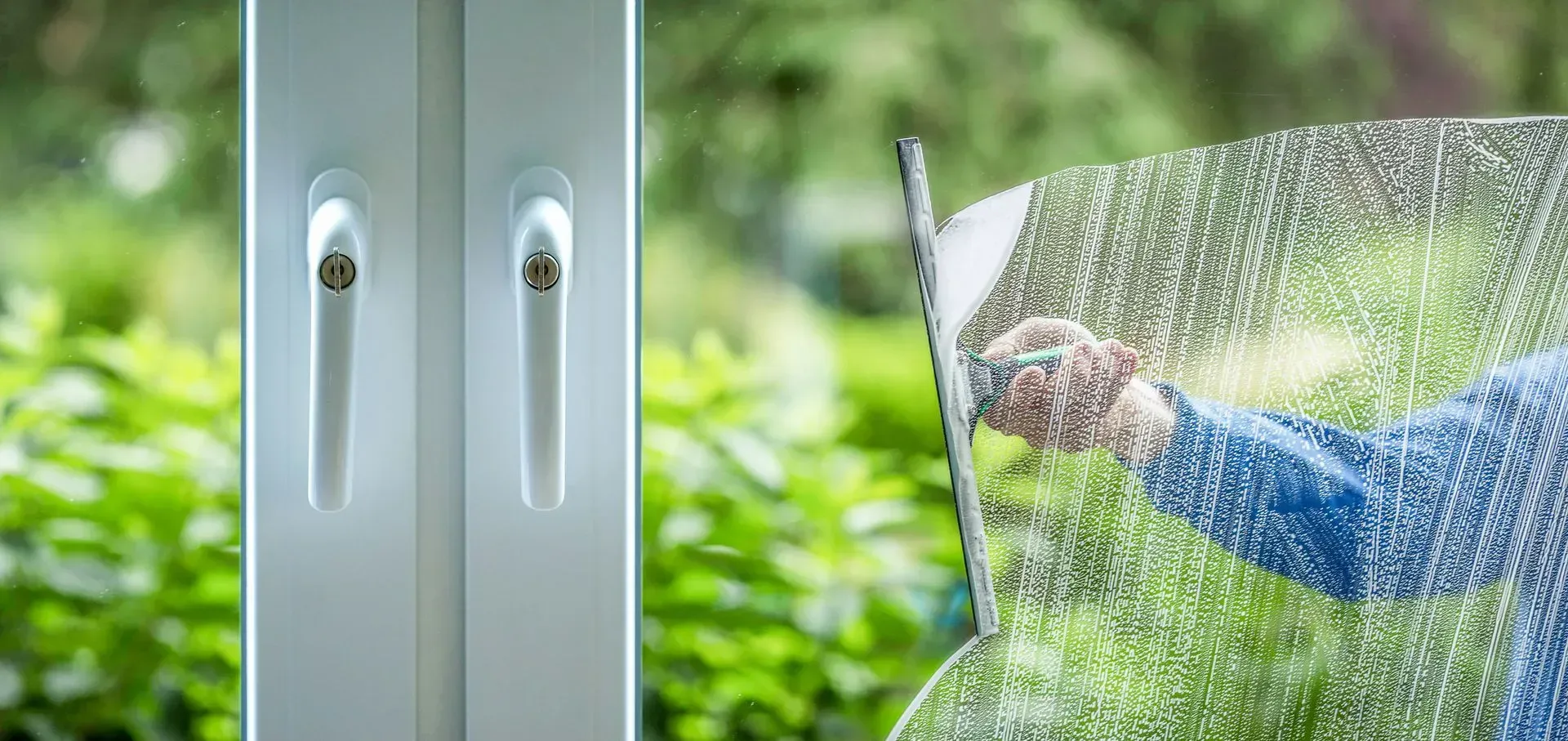 A person is cleaning a window with a squeegee.
