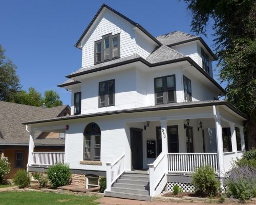 A large white house with a porch and stairs