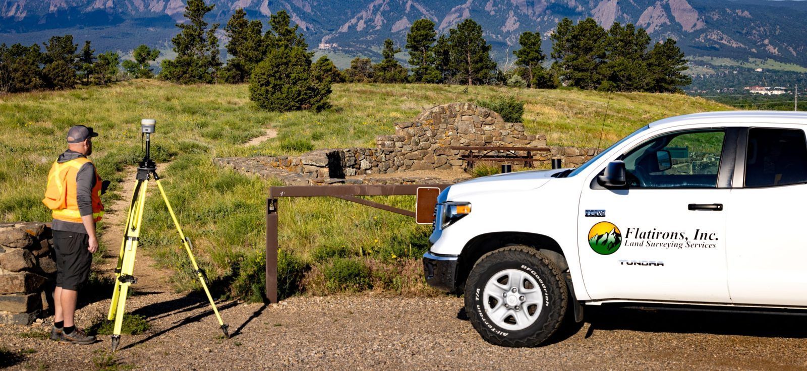 A man is standing next to a white truck in a field.