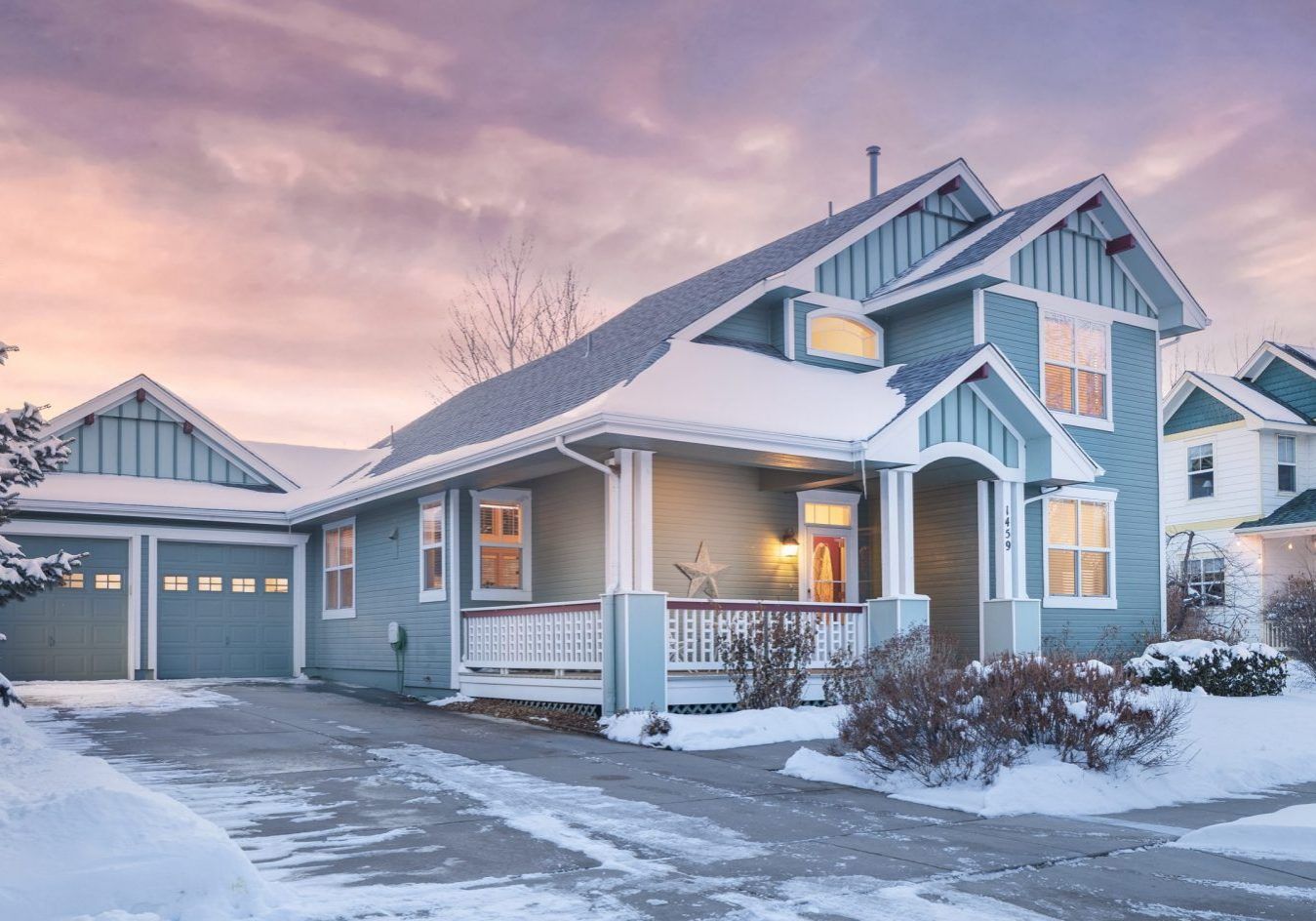 A blue house with a garage is covered in snow brandon rearick englewood colorado