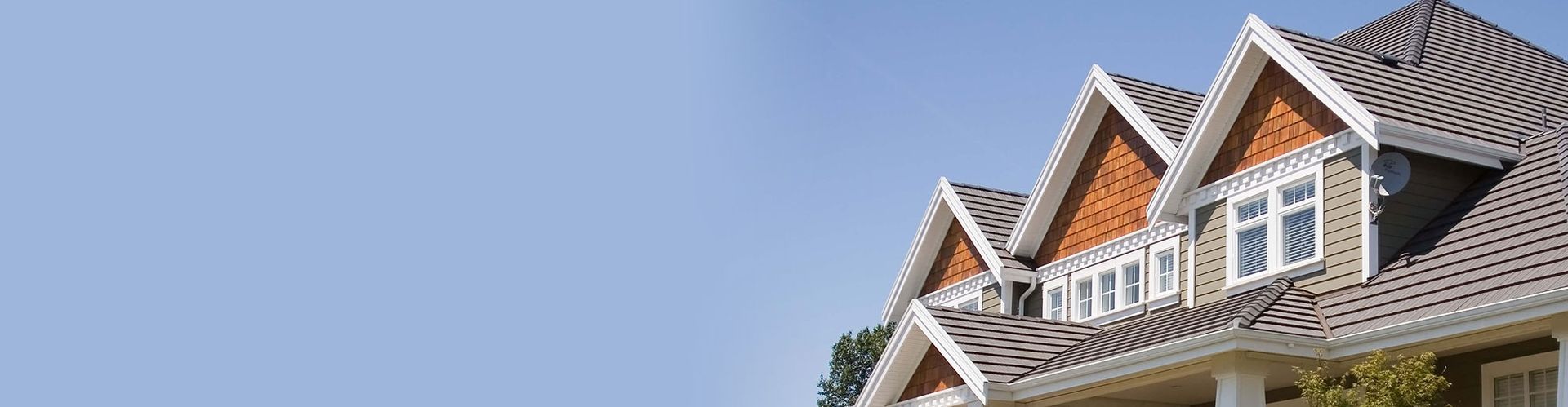 The roof of a house with a blue sky in the background.