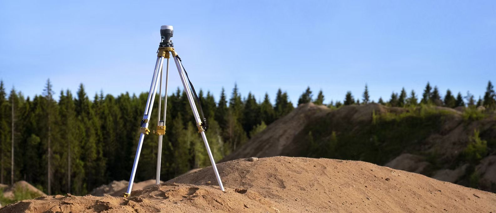 A tripod is sitting on top of a pile of dirt.