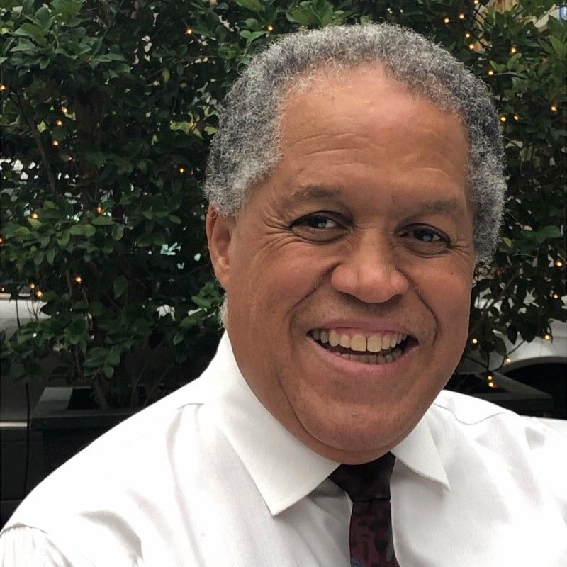 a man in a white shirt and tie is smiling for the camera