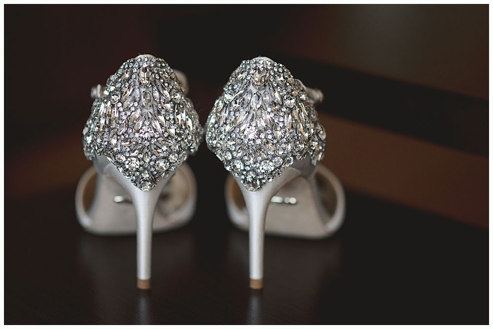 Wedding details: Earrings, veil with floral embroidery, and bouquet with dark red flowers.