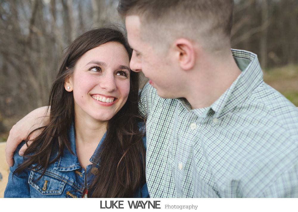 Woman smiles while gazing at man with his arm around her.