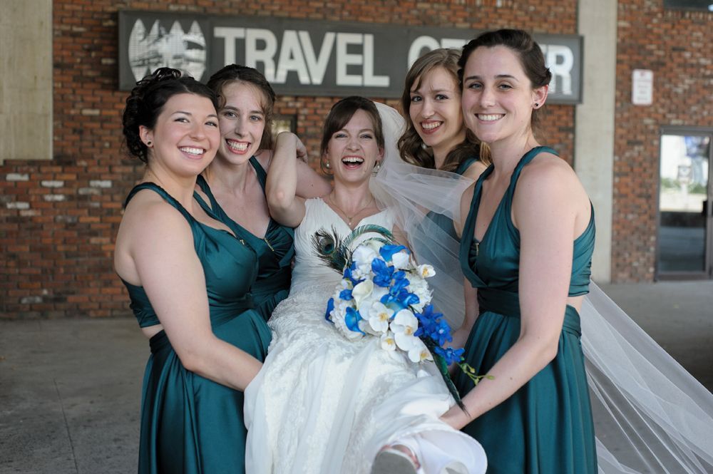 Bride in a white strapless gown adjusts her earring, then smiles holding sunflowers; indoors, window light.