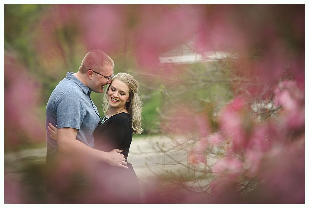 Wedding couple in forest; one embraced, one poses.