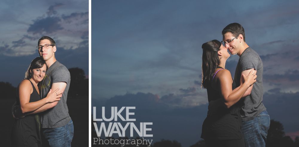 Couple embraces and kisses under a twilight sky; Luke Wayne Photography logo.