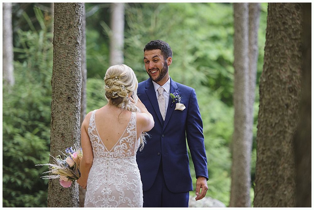 Wedding ceremony: Bride and groom walking toward barn, bridesmaids in red dresses holding bouquets.
