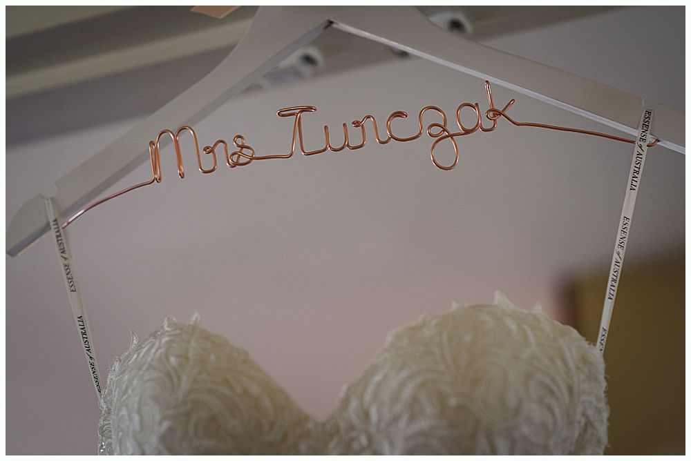 Woman holding a glass, smiling. Another woman is visible in the background, also smiling. Black and white.