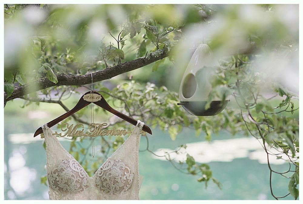 Wedding details: Earrings, veil with floral embroidery, and bouquet with dark red flowers.