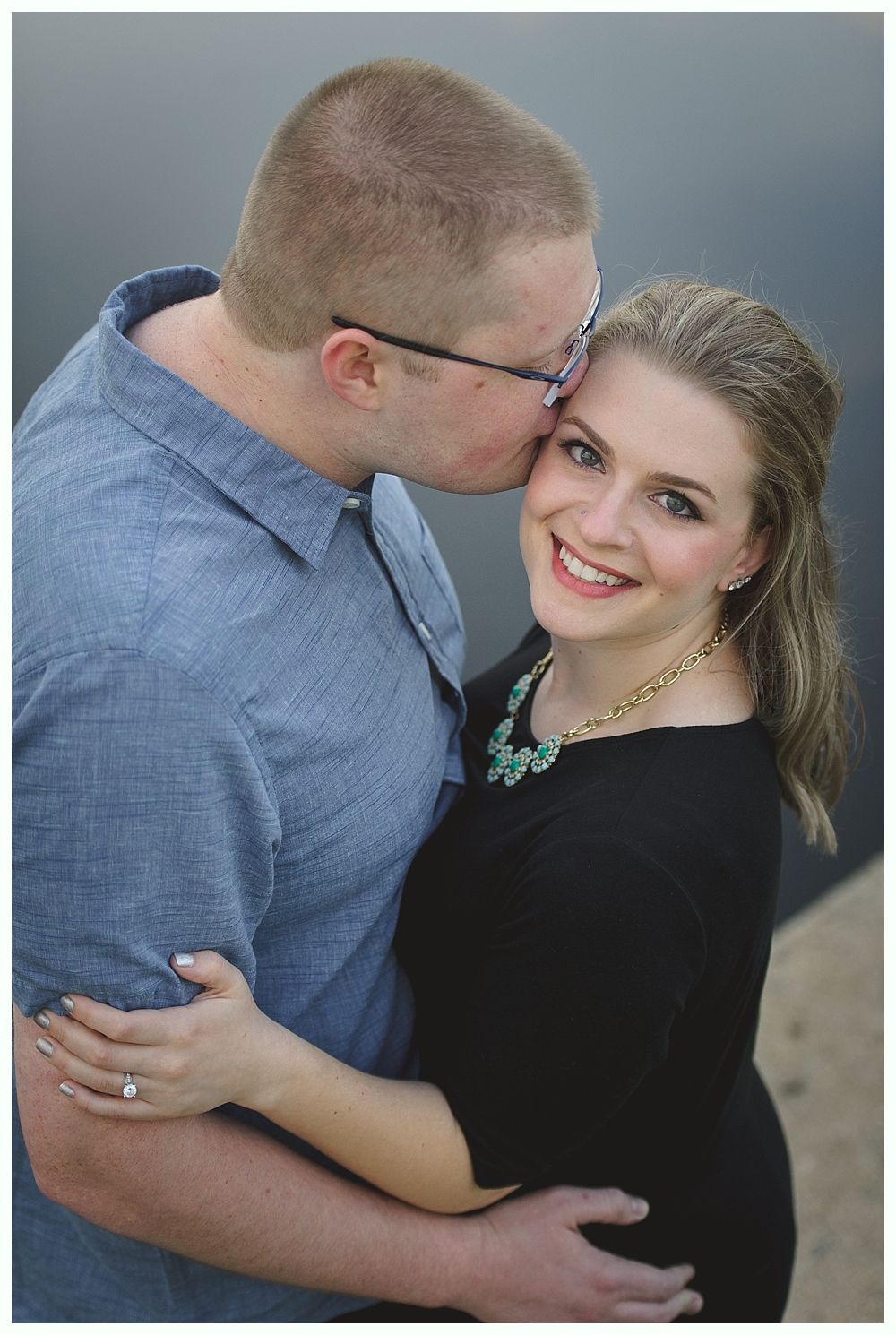 Newlyweds walk down aisle holding hands, sunflowers, gazebo in background.