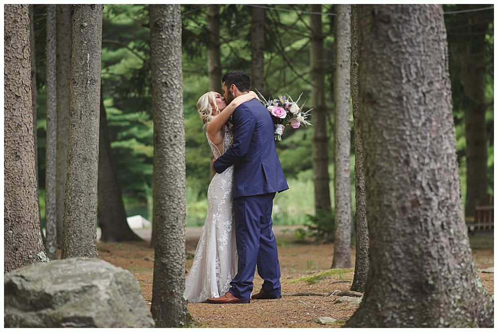 Bride walking with her father down an outdoor aisle; fall trees and guests in background.