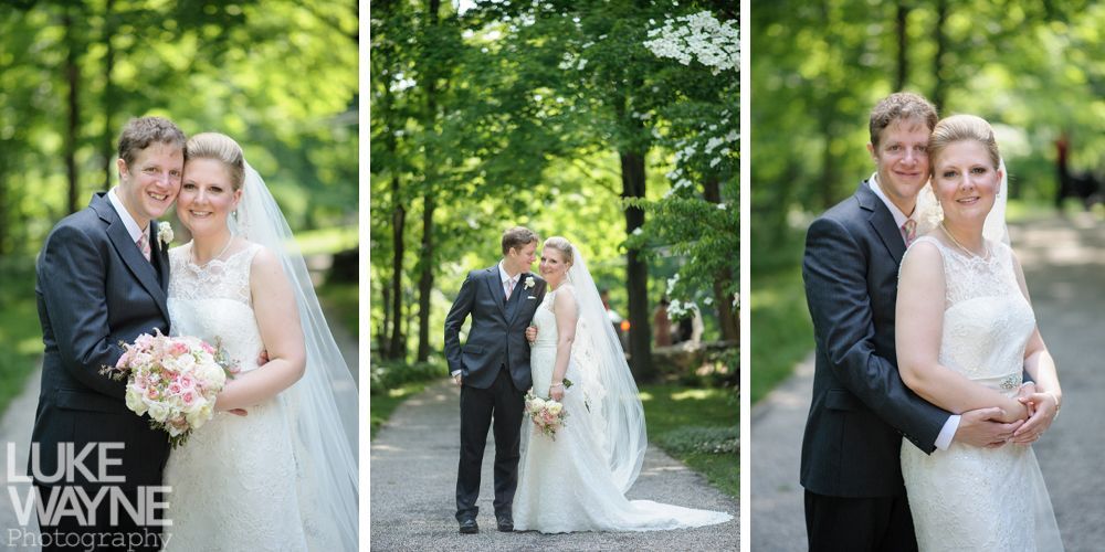 A bride and groom pose for wedding photos on a path lined with trees.
